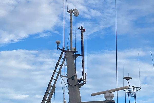 Ship mast with a white PTZ and radar
