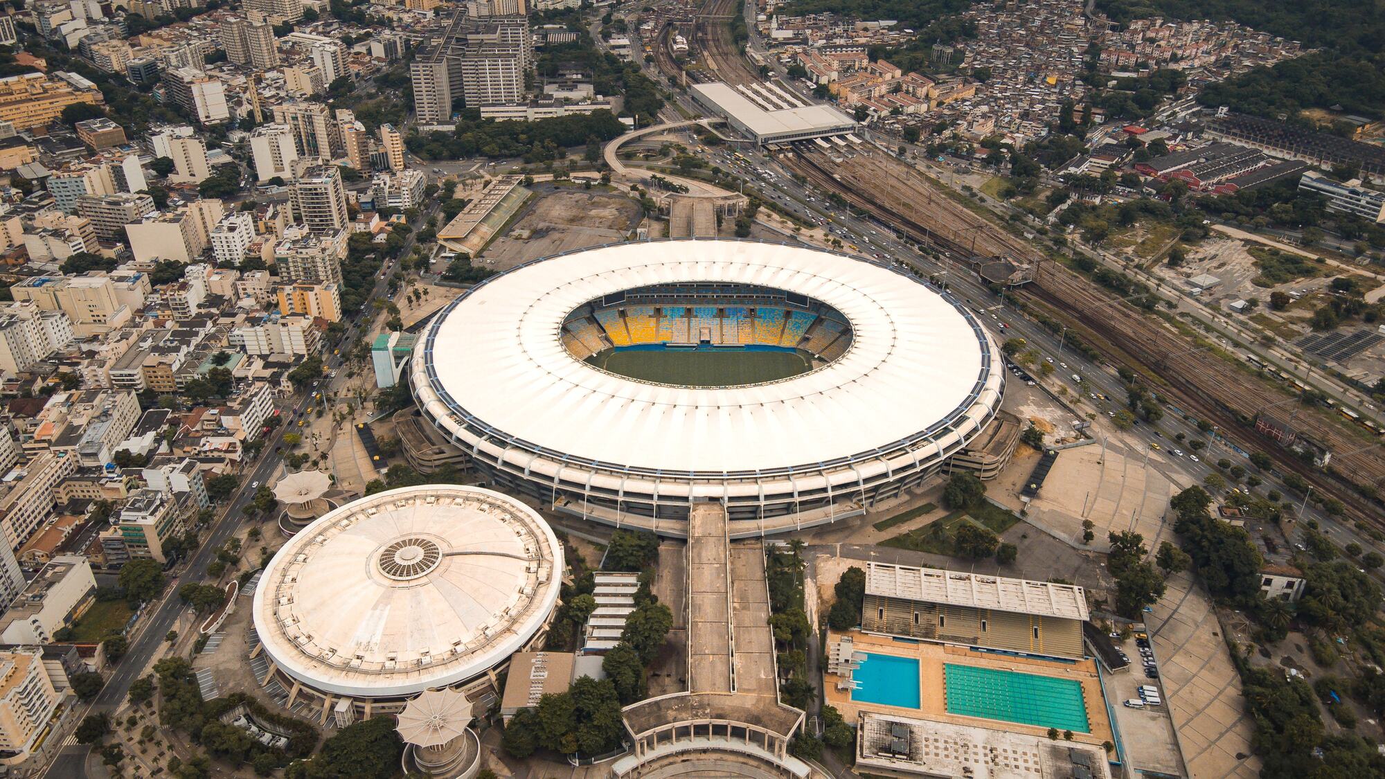 Aerial view of a large stadium in a dense city
