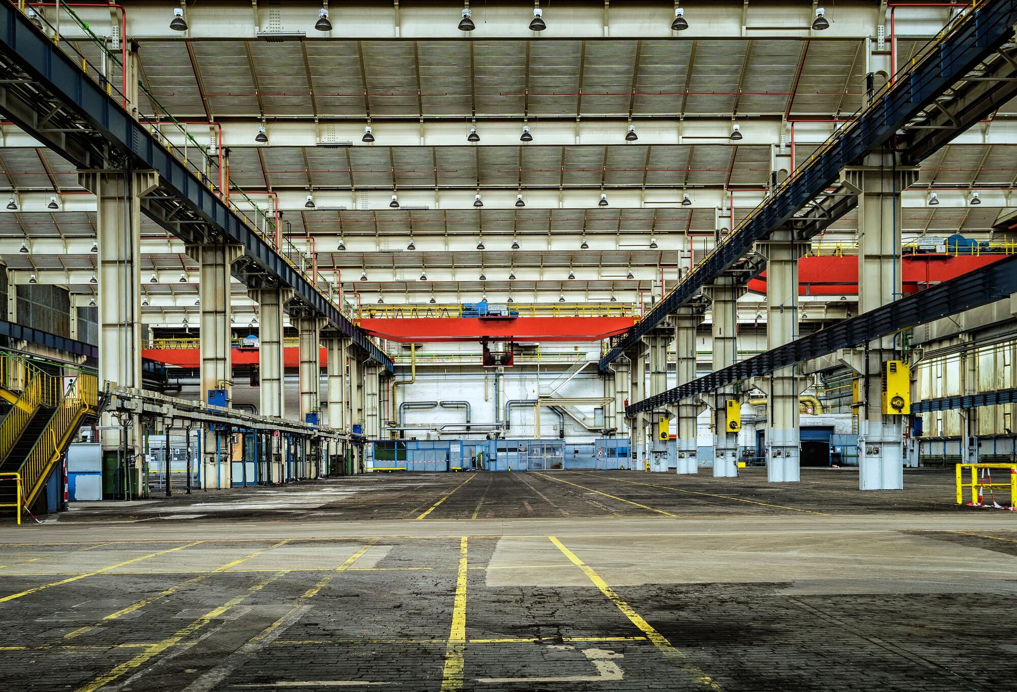 Empty industrial warehouse hall with overhead cranes